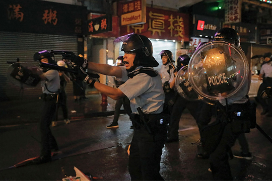 Hong Kong police draw guns on protesters on Sunday [Source: Hong Kong Associated Press]